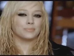A loira com um penteado quadra a masturbar a buceta de listrado meias